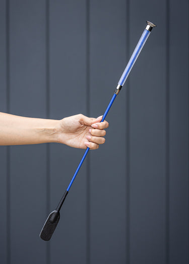 Hand holding a blue equestrian whip against a dark background