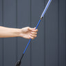 Hand holding a blue equestrian whip against a dark background